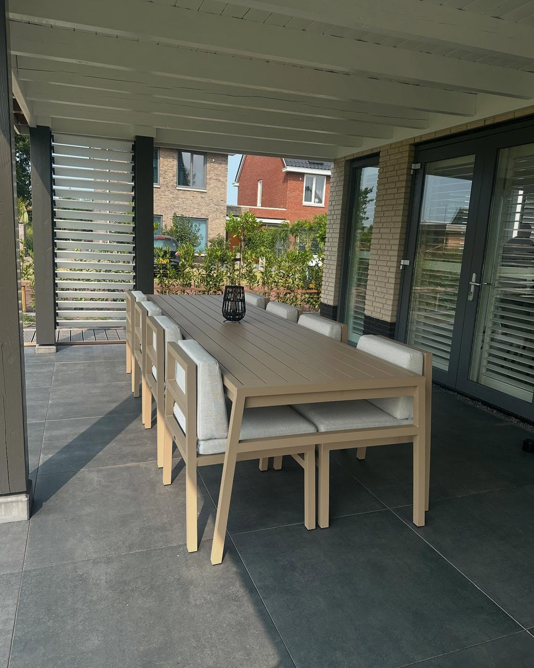 FALAIN diningset onder een veranda met zicht op de tuin