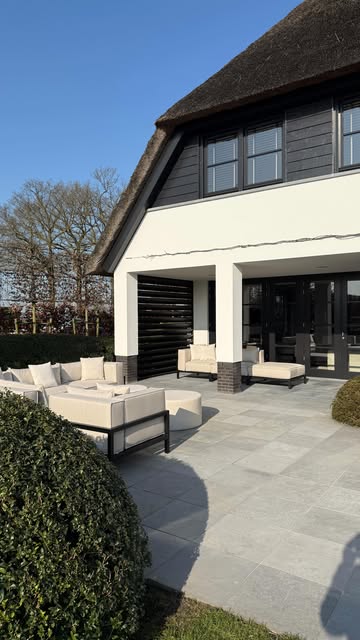 FALAIN loungeset bij een villa met rieten kap