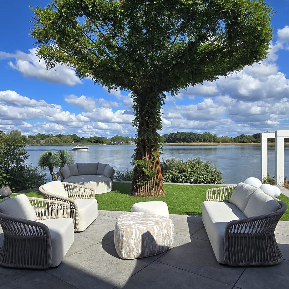 FALAIN loungeset en daybed in een tuin aan het water
