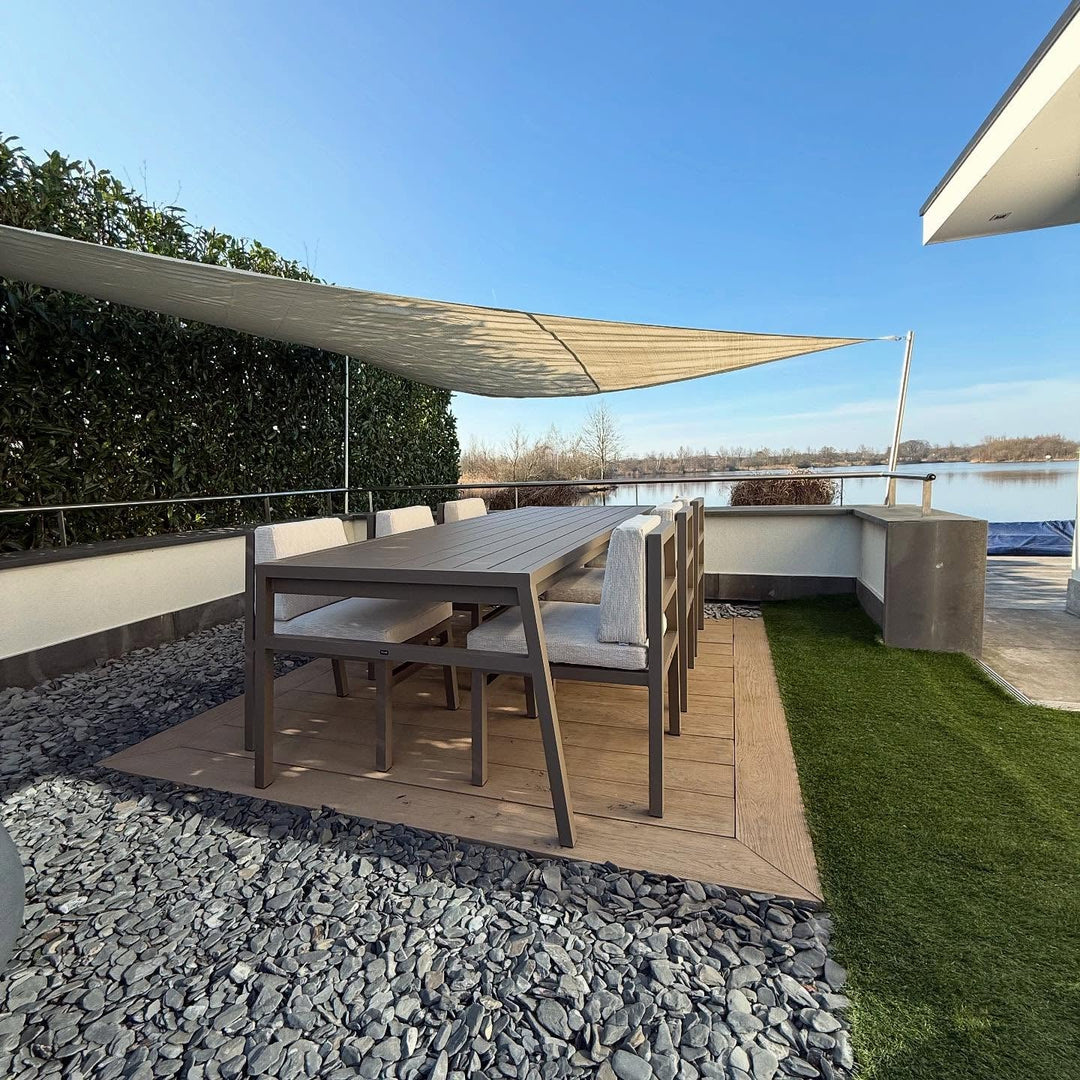 FALAIN diningset onder een zonnezeil met uitzicht op het water